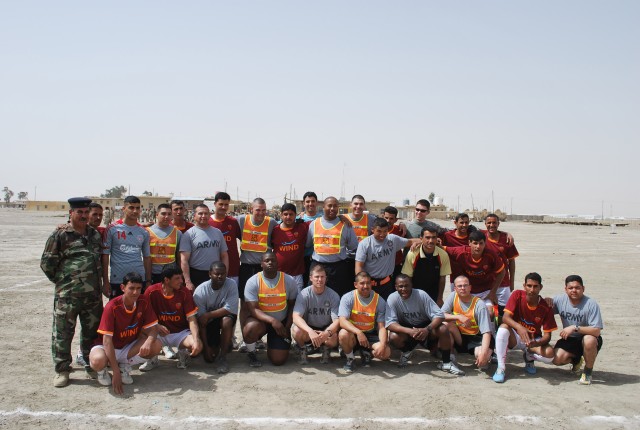 Soldiers assigned to 27th Brigade Support Battalion, 4th Brigade Combat Team, 1st Cavalry Division and the Iraqi Army's 10th Motorized Transport Regiment pause for a photograph prior to a soccer match at Camp White Horse near Contingency Operating...