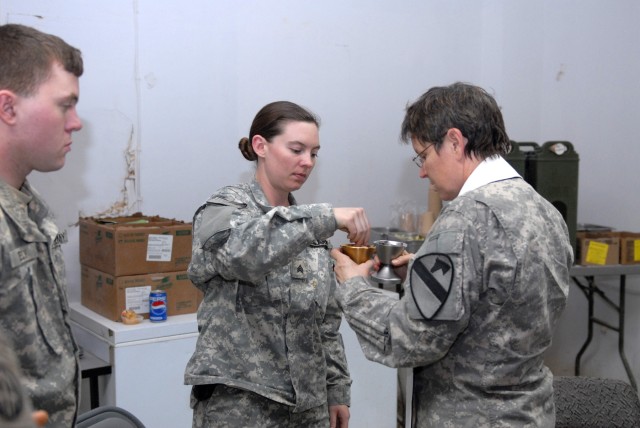 BAGHDAD - Chaplain (Lt. Col.) Barbara Sherer administers communion to Sgt. Sheena Barnett of the 492nd Civil Affairs Battalion, at Joint Security Station Hope on Easter Sunday evening. Assigned to the 3rd Brigade Combat Team, 82nd  Airborne...