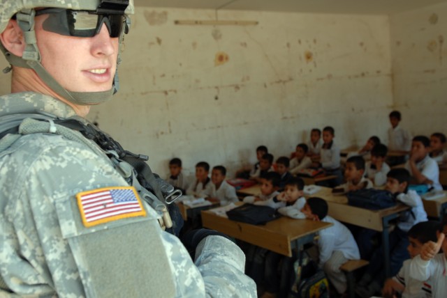 BAGHDAD - Spc. Caleb Eckart, a combat medic from Morgantown, Ind., assigned to 1st Squadron, 7th Cavalry Regiment, visits a classroom in Boob al-Sham here, April 13. Throughout the day, the school is has two separate shifts of students - Abu...