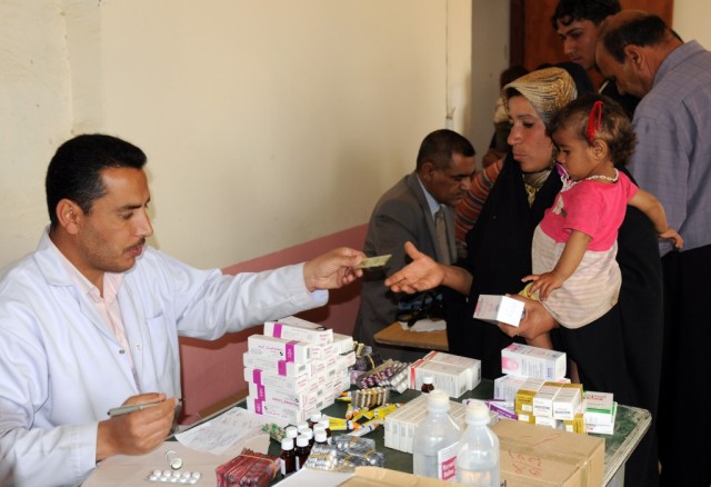 BAGHDAD - A staff member from the Lutifiyah Public Health Center gives patients medication at Kinana School as part of a mobile medical clinic containing medical supplies and equipment that went to the school to provide care to students and...