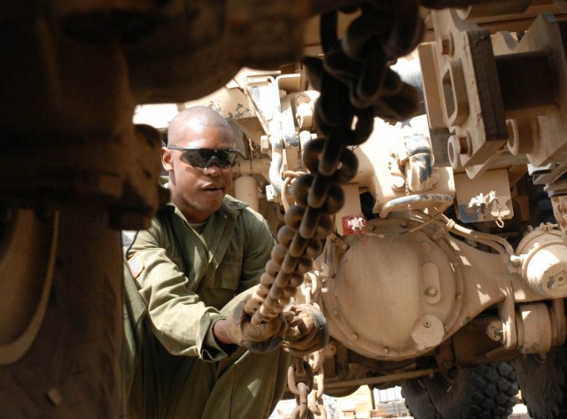 Camp Taji, Iraq - Norfolk, Va. native Sgt. Damen Miller, a recovery noncommissioned officer for Company B, 115th "Muleskinners" Brigade Support Battalion fastens chains to recover a downed Mine Resistant Ambush Protected vehicle April 1 here. ...
