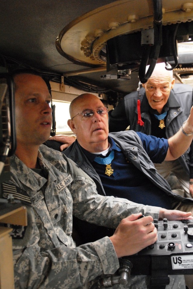 BAGHDAD - Medal of Honor recipients retired Command Sgt. Maj. Gary Littrell (center) and retired Col. Robert Howard (right) watch as Spc. Mikah Appleman of Detriot, operates a gyro-cam inside a Buffalo vehicle. Littrell and Howard visited the 225th E...