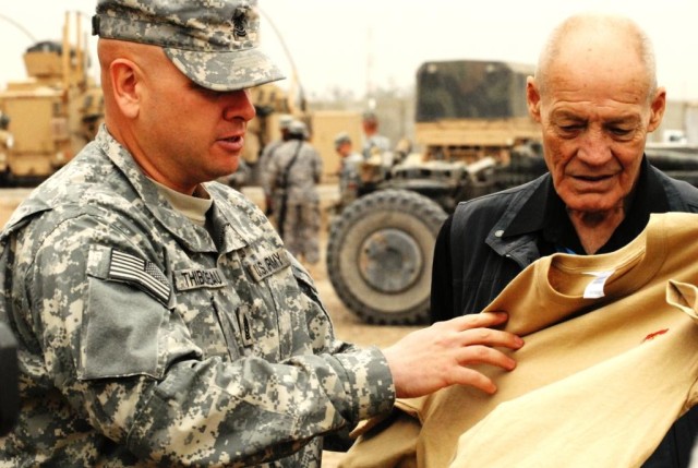 BAGHDAD - Command Sgt. Maj. Frank Thibodeau of Detriot, Mich., gives retired Col. Robert Howard a shirt from the Sgt. 1st Class Paul R. Smith Memorial Run held last week by the 46th Engineer Battalion, 225th Engineer Brigade. Medal of Honor recipient...