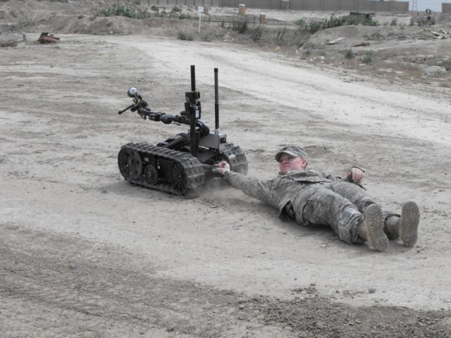 While being dragged, 225th Engineer Brigade Soldier Sgt. Kasandra Deutsch of Pineville, La., demonstrates the power of the Talon robot April 15 during a training exercise with the 9th Iraqi Army Engineer Regiment. The Talon robot system is used to he...