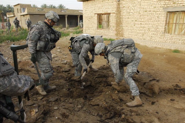 BAGHDAD - Pvt. Johnathon Strain (left), of Olatha, Kan., Pvt Lamont Raynor (center), of Brownsville, N.Y., and Cpl. Kevin Graham, of Oakland, Calif., dig for suspected weapons caches in the Qarghuli Village of the Mahmudiyah Qada during Operation Bei...