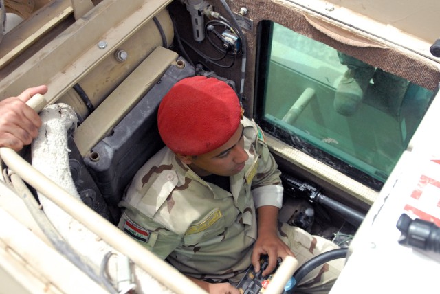 BAGHDAD - An Iraqi engineer student from the 17th Iraqi Army Engineer Regiment sits in the cab of a Husky route clearance vehicle using a control box to maneuver the ferret arm which extends out in front of the vehicle at Joint Security Station...
