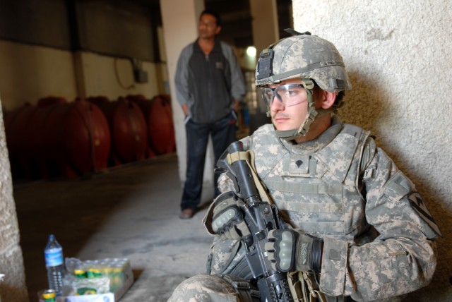 BAGHDAD - Cavalry scout, Spc. James Powell, from Fort Pierce, Fla., assigned to the1st Sqdn., 7th Cav. Regt., 1st BCT, 1st Cav. Div., takes a break inside a water bottling plant during a civil affairs patrol to help raise awareness for a factory owne...