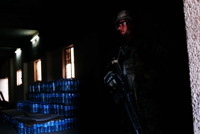 BAGHDAD - Spc. James Powell, a cavalry scout and native of Fort Pierce, Fla., stands guard in the doorway of a water bottling plant in Boob al-Sham here, April 14.  Powell, assigned to Apache Troop, 1st Squadron, 7th Cavalry Regiment, provides securi...