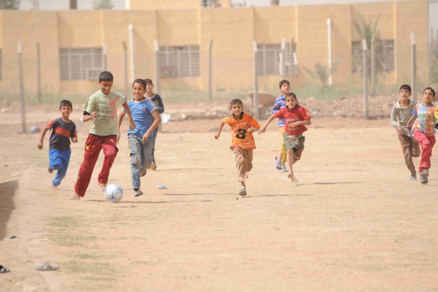 AL-MADAIN, Iraq - Local children in an Al-Madain neighborhood of eastern Baghdad play a pick-up game of soccer after receiving a new donated ball April 18. Paratroopers from the 3rd Brigade Combat Team, 82nd Airborne Division, Multi-National...