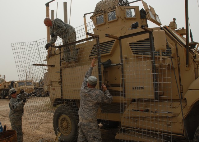 BAGHDAD - Spc. Samantha Schell (left), of Philadelphia, and Sgt. William Funaro of Monroeville, Pa. hand up Hesco wire to Spc. Richard Pfleegor of Jersey Shore, Pa. who positions it on a metal outrigger. The Soldiers of the 328th Brigade Support Batt...