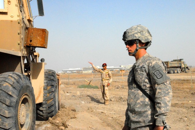 Spc. Ryan Walden, from Huntsville, Ark., a heavy equipment operator with the 277th Engineer Company, 46th Eng. Battalion, 225th Eng. Brigade, looks on to make sure Iraqi Army Soldiers are using the right procedures for maneuvering heavy equipment on ...