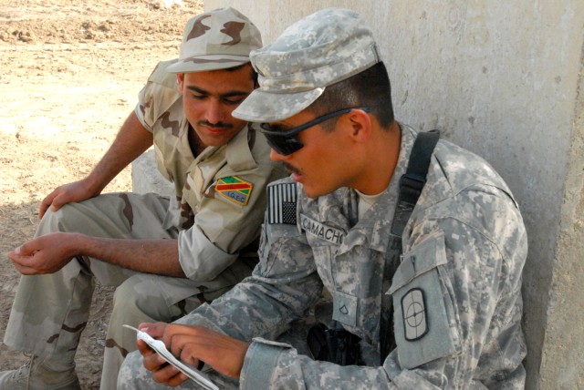 Pfc. Santos Camacho, from Pleasanton, Texas, a heavy equipment operator with the 277th Engineer Company, 46th Eng. Battalion, 225th Eng. Brigade, takes time to practice some Arabic phrases with an Iraqi Army Soldier on Victory Base Complex April 16, ...