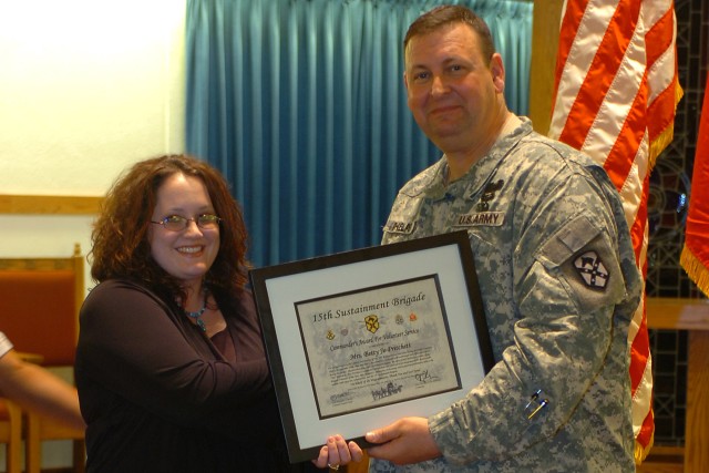 Col. Larry Phelps, the commander of the 15th Sustainment Brigade, 13th Sustainment Command (Expeditionary), presents the volunteer of the year award to Betty Jo Pritchett, a volunteer from the 49th Transportation Battalion for her efforts over the pa...