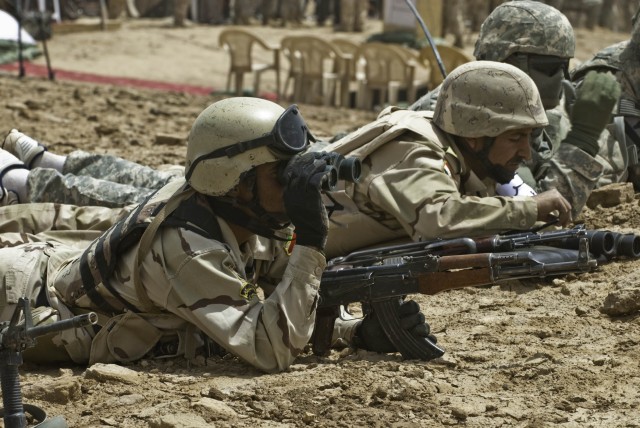 An Iraqi forward observer watches the impact zone with binoculars during the 10th Iraqi Army Division and Long Knife Brigade's combined arms live-fire exercise in the Maysan province April 19. The two countries' armies worked together in an...