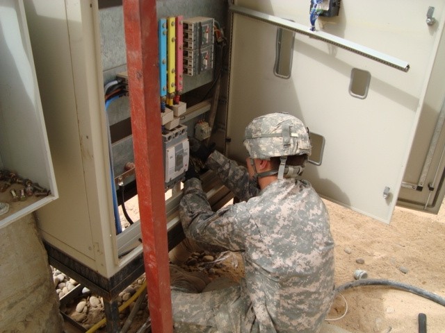 BAGHDAD - Pvt. Daniel Almquist, 46th Engineer Combat Battalion (Heavy), 225th Engineer Brigade, an electrician from Chicago, installs a main distribution panel for electricity at the newly-built battalion aid station on Joint Security Station Ur Marc...