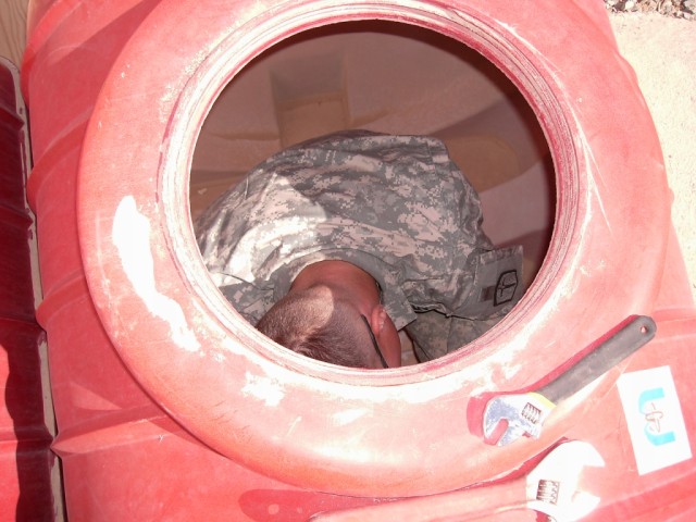 BAGHDAD - Pfc. Jacob Wade, plumber, 46th Engineer Combat Battalion (Heavy), 225th Engineer Brigade, from Flint, Mich., inspects the water tanks that will supply water to hand-washing stations in the newly-built battalion aid station on Joint Security...