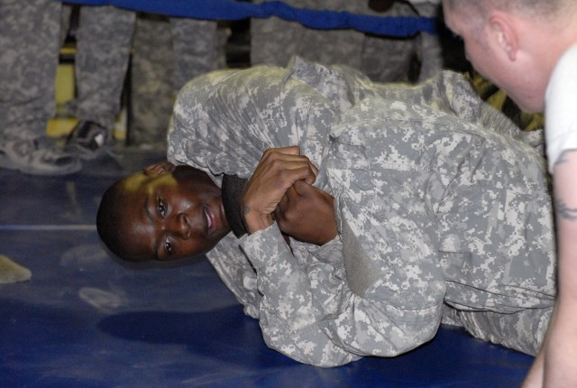 Pfc. Lamarcus Bailey, winner of the 27th Brigade Support Battalion, 4th Brigade Combat Team, 1st Cavalry Division's Modern Army Combatives Tournament, applies a head-lock to another contender in Memorial Hall on Contingency Operating Base Adder,...