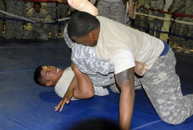 Spc. Gary Bush breaks a grappling move applied by Spc.Tarvery Bowe during the 27th Brigade Support Battalion, 4th Brigade Combat Team, 1st Cavalry Division's Modern Army Combatives Tournament held in Memorial Hall on Contingency Operating Base...