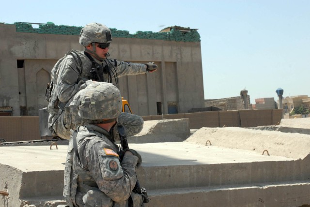 HUSSENIYAH, Iraq - West Point, N.Y. native, 1st Lt. Aaron Shittack, platoon leader for B Troop, 1st Squadron, 7th Cavalry Regiment, points and communicates the barrier layout plan to Birmingham, Ala. native, Cpl. Thomas Robbins, the senior line...
