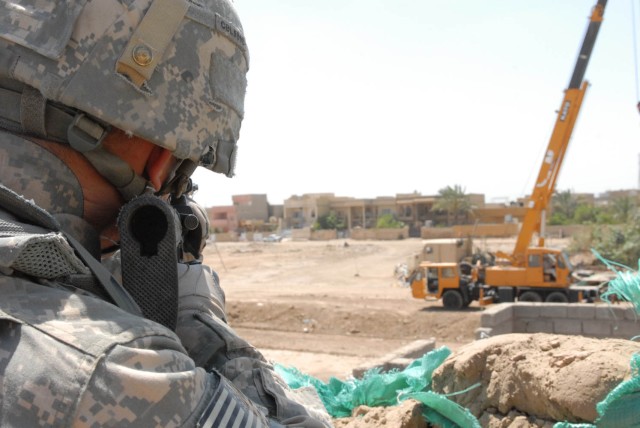 HUSSENIYAH, Iraq - Verona, Pa. native Spc. Nathan Lohr, dismount for B Troop, 1st Squadron, 7th Cavalry Regiment  provides over watch security from the roof of the National Police station during the barrier reinforcement mission on Joint Security...
