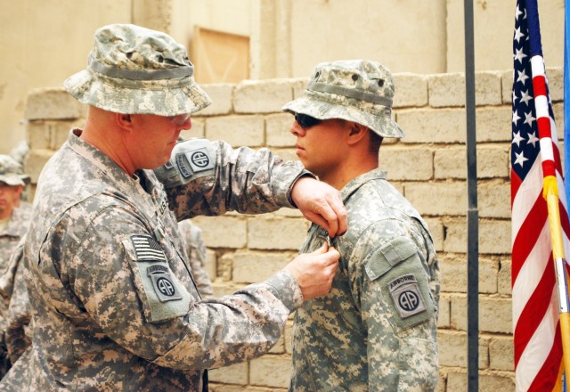 BAGHDAD - Col. Timothy McGuire (left), commander of the 3rd Brigade Combat Team, 82nd Airborne Division, Multi-National Division-Baghdad pins an Army Commendation Medal with Valor on Spc. Gaspar Grijalva, during a ceremony April 25 at Joint...