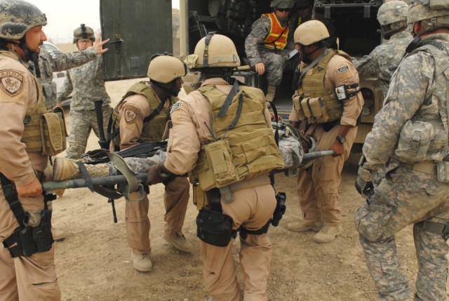 BAGHDAD - Members of a rapid response team load a wounded Soldier onto a field line ambulance from a nearby troop medical clinic on Victory Base Complex during a mass casualty training exercise held on Apr. 24. The exercise was designed to bring...