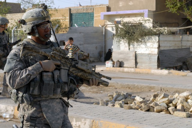 BAGHDAD - Cpl. Anthony Jackson, from Wichita, Kan., a sniper with Headquarters and Headquarters Company, 2nd Battalion, 5th Cavalry Regiment, walks down a street in the Sadr City district here, April 19. The mission had the 2-5 troopers patrolling th...
