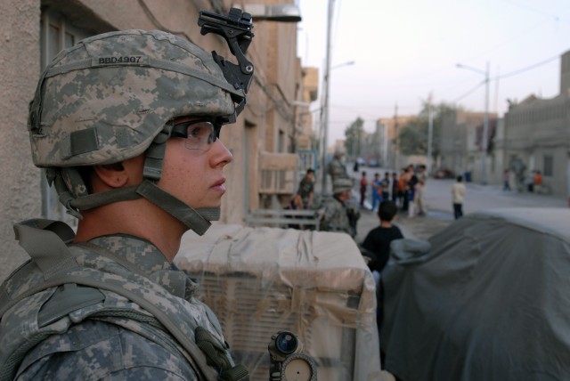 BAGHDAD - Spc. Nicholas Dunn, a sniper with Headquarters and Headquarters Company, 2nd Battalion, 5th Cavalry Regiment who hails from Independence, Mo., keeps a watchful eye on a street in Sadr City, April 19. Soldiers from 2-5 Cav. patrol these stre...