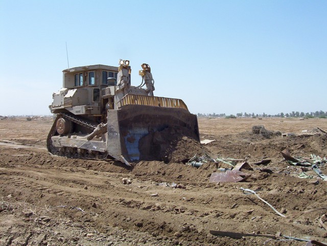 BAGHDAD - One of the largest bulldozers in the military arsenal, the D-9, being driven by Command Sgt. Maj. Joe Major of the 225th Engineer Brigade, 1st Cavalry Division, pushes debris around Sather Airbase, located on Victory Base Complex, April 27....