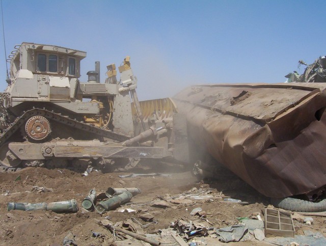 BAGHDAD - One of the largest bulldozers in the military arsenal, the D-9, driven by Command Sgt. Maj. Joe Major of the 225th Engineer Brigade, 1st Cavalry Division, pushes debris around Sather Airbase, located on Victory Base Complex, April 27. U.S. ...