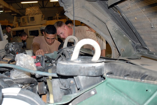 CAMP LIBERTY, Iraq - Spc. Phillip Corbin (right), a mechanic from Braidwood, Ill.,  assigned to Headquarters Support Company, Division Special Troops Battalion, 1st Cavalry Division, gives hands-on training on how to remove a steering gear box to Has...