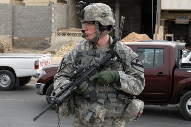 BAGHDAD - Pfc. Daniel Owen, from Eden Rapids, Mich., Company B, 2nd Battalion, 5th Cavalry Regiment, scans the area after dismounting a Mine-Resistant Ambush-Protected vehicle in Sadr City, April 26. The main objective of Co. B's patrol was to...