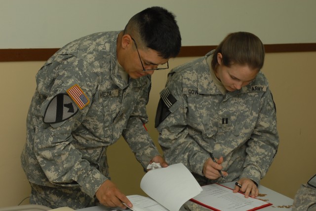 Capt. Katherine Gowell, a Harker Heights, Texas, native and a judge advocate general for 2nd Brigade Combat Team, 1st Cavalry Division, assists Pfc. Efrain Meza, an Arequipa, Peru, native and a food service specialist with Headquarters and...