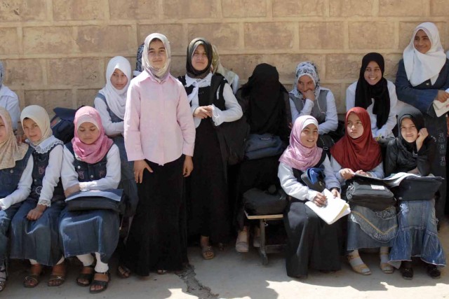 A group of girls are gathered in the shade of the Al Shaheed Hassan School in Muhallabiyah, Iraq. The school reopened after its renovation that was organized by local civic leaders, the local Iraqi Police and Iraqi Army and Coalition Force units in t...