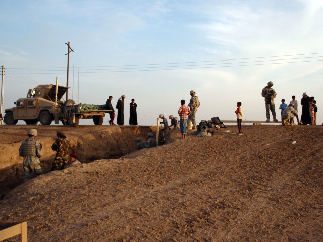 Soldiers with 2nd Battalion, 41st Iraqi Army Brigade, and 5th Battalion, 82nd Field Artillery Regiment, 4th Brigade Combat Team, 1st Cavalry Division repair Route Phoenix, a damaged roadway traveled by Coalition forces and the local Iraqi...