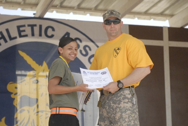 Command Sgt. Maj. Dennis Eger, the senior enlisted Soldier assigned to the 4th Brigade Special Troops Battalion, 4th Brigade Combat Team, 1st Cavalry Division, awards Sgt. Mayra Montelongo, a supply sergeant in the 4th Brigade Special Troops Battalio...