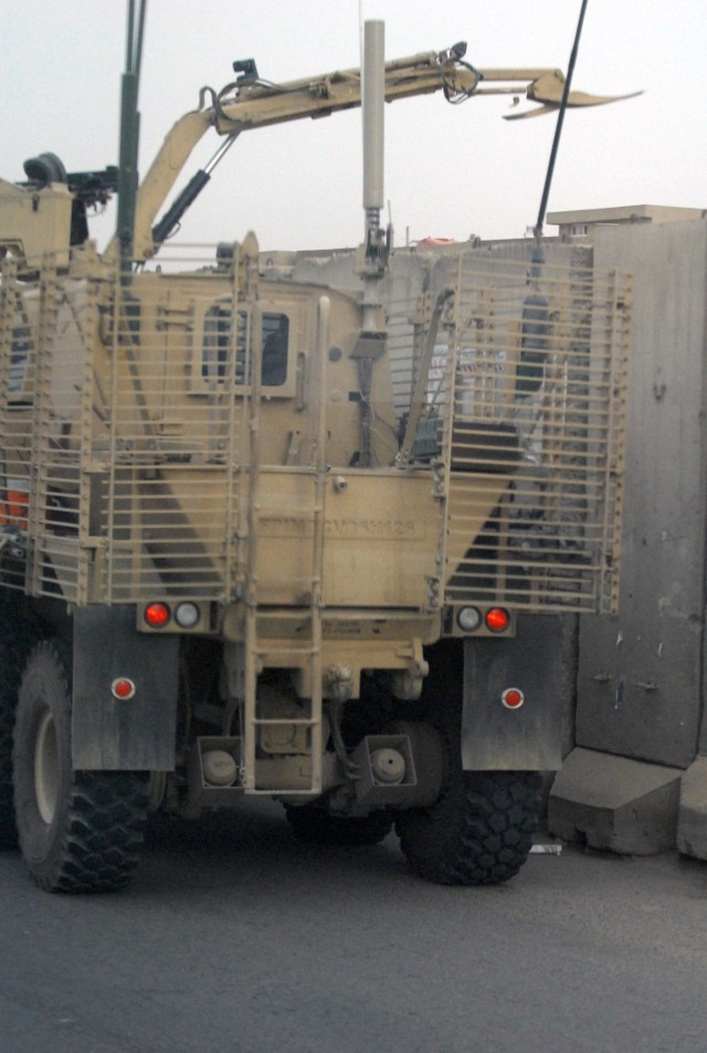 BAGHDAD - An operator of the specialized route clearance vehicle, the Buffalo, with the 515th Sapper Company, 515th Engineer Battalion, 225th Eng. Brigade inspects for possible explosive devices on the other side of a barrier during a route...