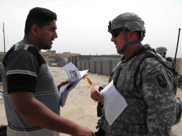 BAGHDAD - Tioga, La. native, Sgt. 1st Class Rodney Nordby aka "Alpha Dog," of the 225th Engineer Brigade and an Iraqi contractor discuss current plans to build a wall near a clinic in Abu Ghraib May 4. Nordby oversees quality assurance and quality...