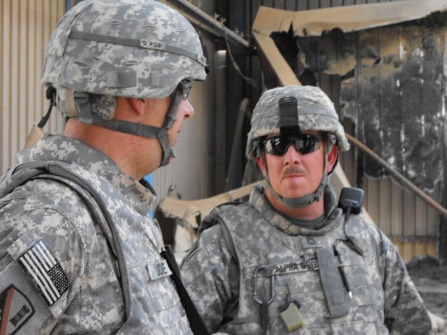 BAGHDAD - Hornbeck, La. native, Lt. Col. Michael Ude (left) and Sgt. 1st Class Rodney Nordby, 225th Engineer Brigade quality control team, who hails from Tioga, La., stand inside of what is left of a fire-damaged cold storage building for a milk...