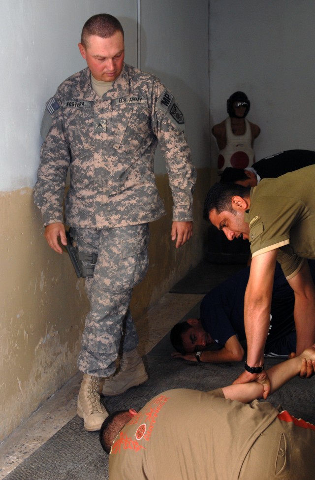 BAGHDAD - Cpl. Andy Kostera, from Cape Coral, Fla., assigned to 810th Military Police Company, 91st MP Battalion, 8th MP Brigade, inspects hand-to-hand techniques applied by Iraqi Police at Camp Fiji, on Victory Base Complex here, May 5. Kostera, a f...