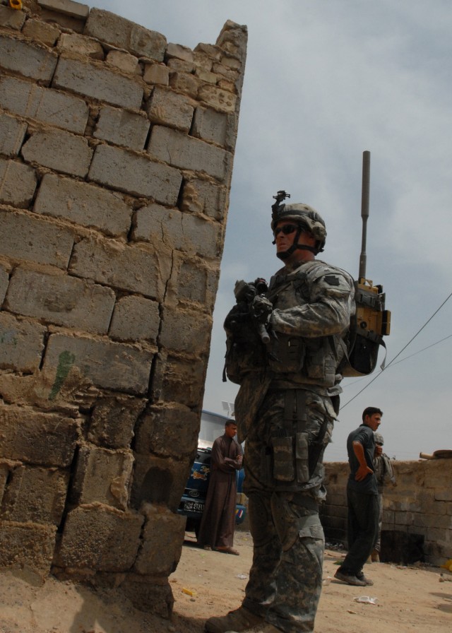 TAJI, Iraq - Spc. Aaron Gardner of Saint Mary's, Pa. watches an alleyway in Taji Market, north of Baghdad, May 4. Gardner and other Soldiers of Company C, 1st Battalion, 112th Infantry Regiment, 56th Stryker Brigade Combat Team conduct regular patrol...