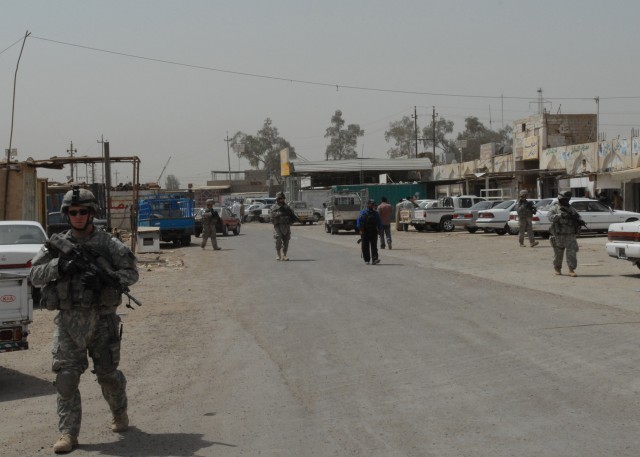 TAJI, Iraq - Spc. Aaron Gardner (left) of Saint Mary's, Pa., leads a patrol of Iraqi Army and Pennsylvania Army National Guard Soldiers through Taji Market, north of Baghdad, May 4. Gardner and his fellow guardsmen are from Company C, 1st Battalion, ...