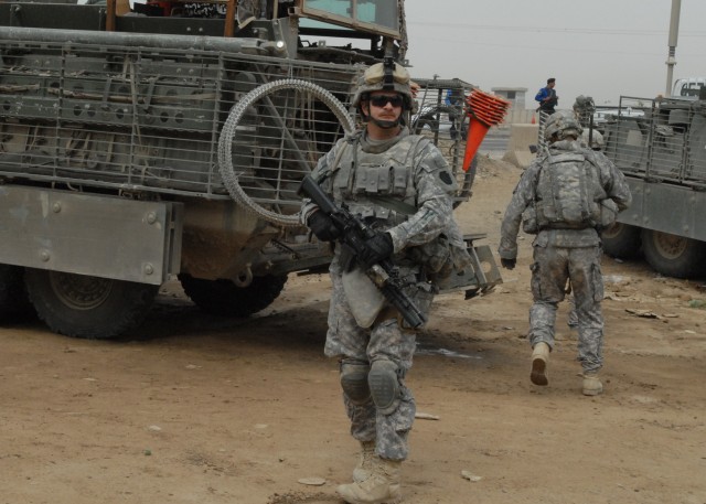 TAJI, Iraq -Spc. John Schloder of Ridgeway, Pa., a Soldier with Company C., 1st Battalion, 112th Infantry Regiment, 56th Stryker Brigade Combat Team, pulls security May 4 as other Soldiers prepare to board Stryker vehicles outside the Iraqi Police st...