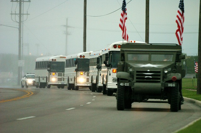 The buses are led in by 4th Infantry Division's half track as hundreds of families, friend and fellow Soldiers wait for them to arrive home from Iraq May 4, in front of the 4th Inf. Div. Headquarters. A small contingent of Soldiers from the 4th...