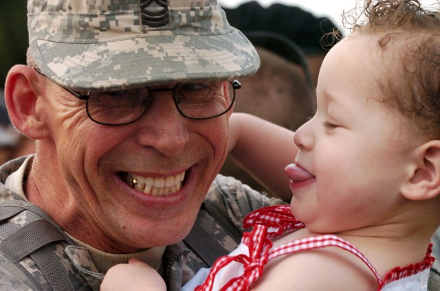 Master Sgt. Timothy Shapiro, 2nd Battalion, 12th Cavalry Regiment, 4th Brigade Combat Team, 1st Cavalry Division, of Farmville, Va., can't contain his happiness as he is greeted by this wife and 2-year-old daughter Lia Dante, as he and a small...