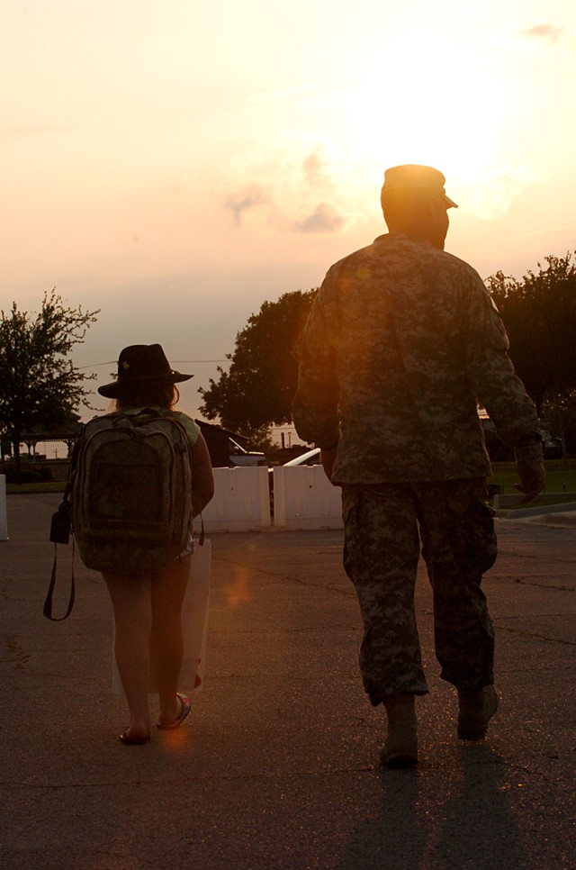 Capt. Ronald Holmes, a physician's assistant assigned to 1st Squadron, 9th Cavalry Regiment, 4th Brigade Combat Team, 1st Cavalry Division, of Blackwell, Okla., walks alongside his 10-year-old daughter, Baylee, who carried his equipment for him...