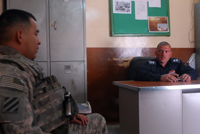 Sgt. 1st Class Miguel Casarez (left), San Antonio, Texas native, and a platoon sergeant in 4th Squadron, 9th Cavalry Regiment, 2nd Brigade Combat Team, 1st Cavalry Division, meets with Lt. Abbas of the Daquq police to discuss recent arrests and...