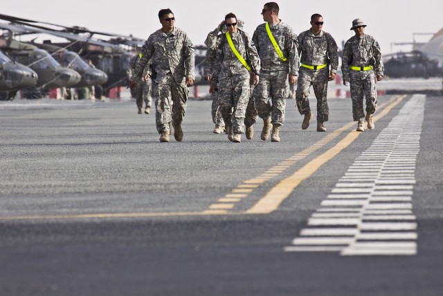 Helicopter mechanics from the 1st Air Cavalry Brigade, 1st Cavalry Division, make their way down the flight line at Camp Beuhring, Kuwait, May 4. Soldiers from the "Warrior" brigade will spend over two weeks in Kuwait completing training and...