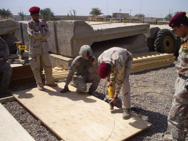 BAGHDAD - San Antonio native, Sgt. Mark Jordan, 46th Engineer Combat Battalion (Heavy), 225th Eng. Brigade, team leader, instructs a team of 23rd Iraqi Army Engineer Regiment Soldiers on how to outfit their concrete guard towers with wooden safety...