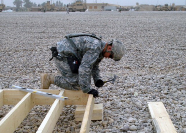 BAGHDAD - Spc. Chance Bailey from Russellville, Ark., a member of the 46th Engineer Battalion, 225th Eng. Brigade, nails together a floor system frame to prepare it for sheathing. The 46th Eng. Bn. is building 30 B-Huts, a dining facility...